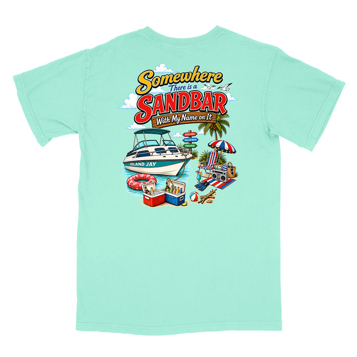 A mint green short-sleeve t-shirt with a colorful graphic print on the back. The graphic features the text 'Somewhere There is a SANDBAR Wish My Name was It' above an illustration of a boat, beach umbrella, cooler, and towels.