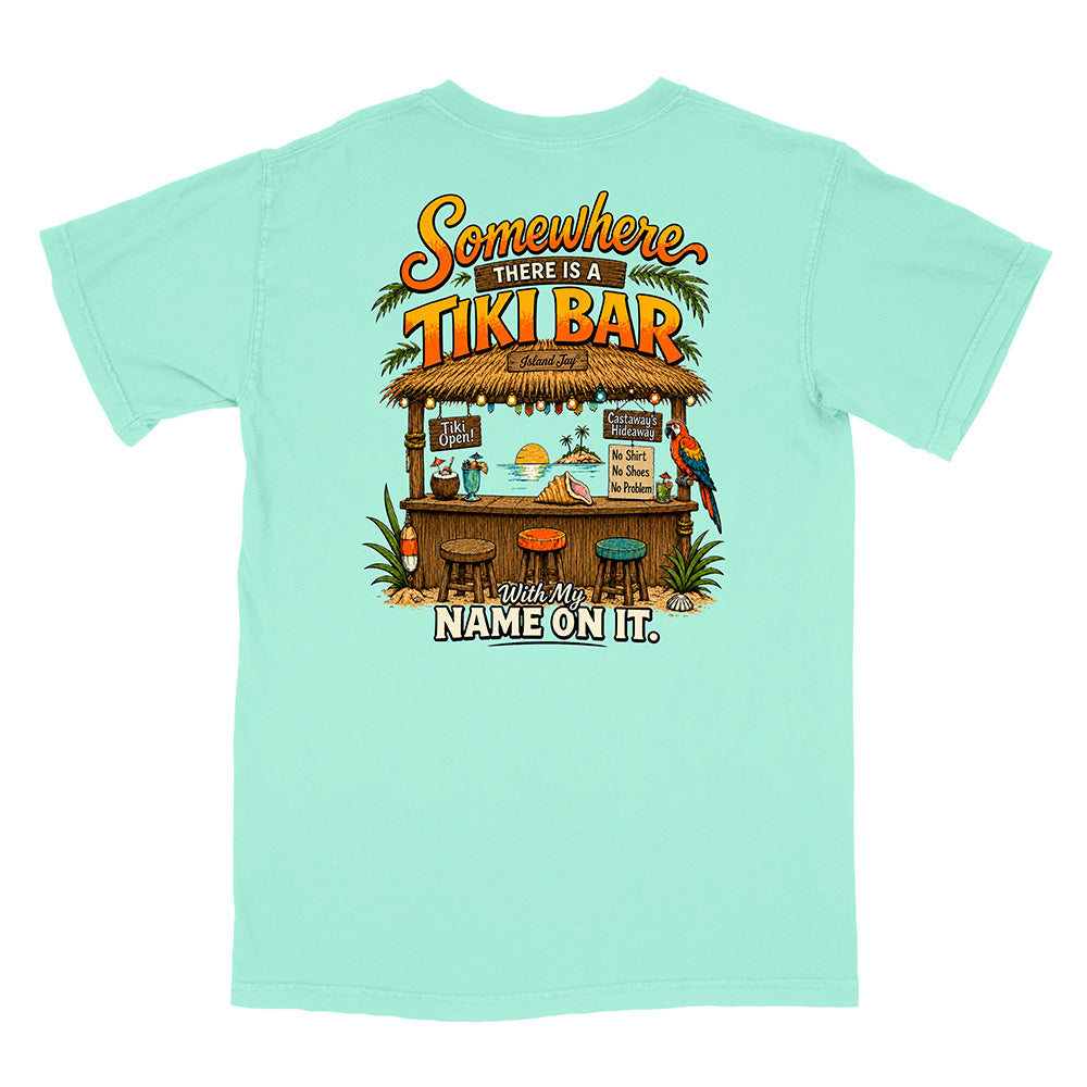 A mint green short-sleeve t-shirt shown from the back, featuring a colorful graphic of a tropical tiki bar with the text 'Somewhere THERE IS A TIKI BAR' and 'With My NAME ON IT.'.