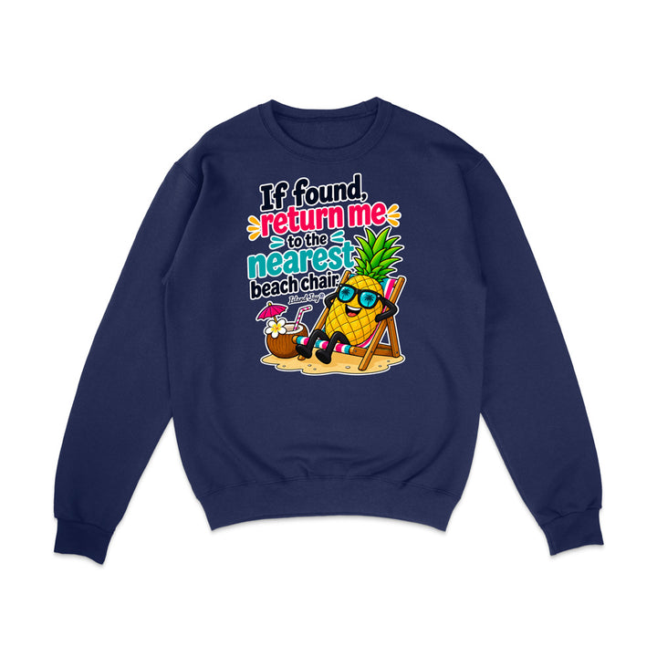A navy blue crewneck sweatshirt with a colorful graphic print on the front. The graphic features a cartoon pineapple wearing sunglasses and a beach chair next to a coconut drink, with the text 'If found, return me to the nearest beach chair'.