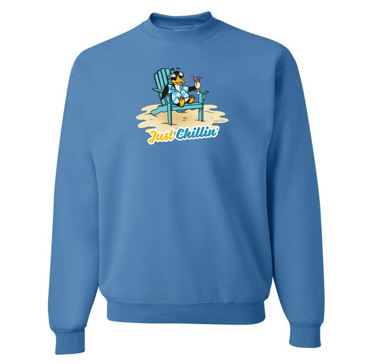 Blue sweatshirt with a graphic of a penguin in a chair and 'Just Chillin' text on a white background