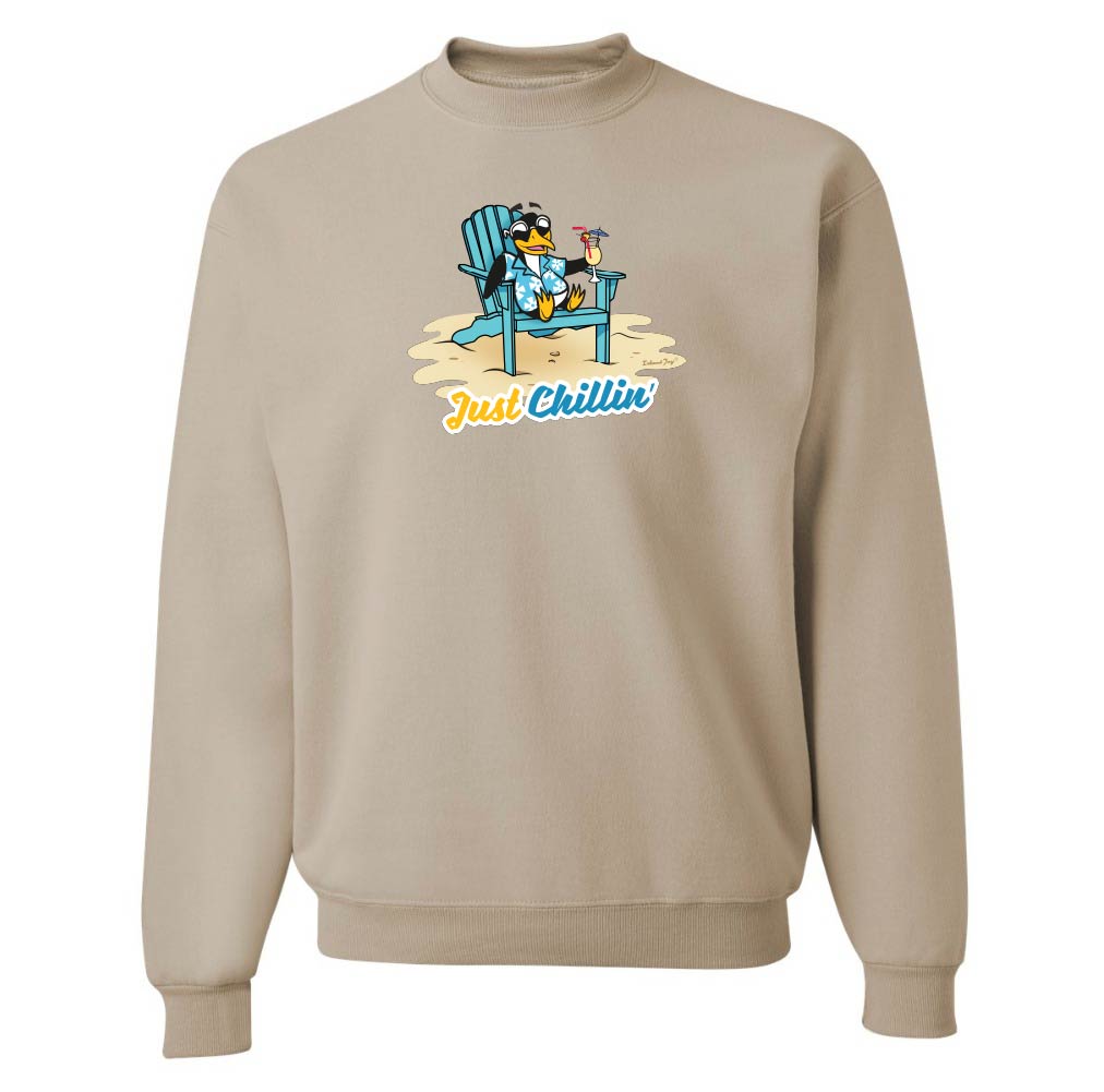 Beige sweatshirt with a graphic of s cartoon penguin on a beach chair and 'Just Chillin' text.