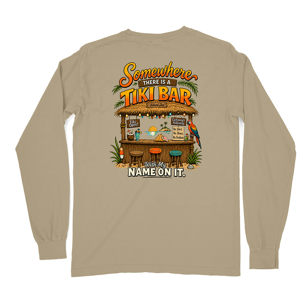 A beige long-sleeve t-shirt shown from the back, featuring a colorful graphic print of a tropical 'Tiki Bar' with the text 'Somewhere THERE IS A TIKI BAR' and 'With My NAME ON IT.'.