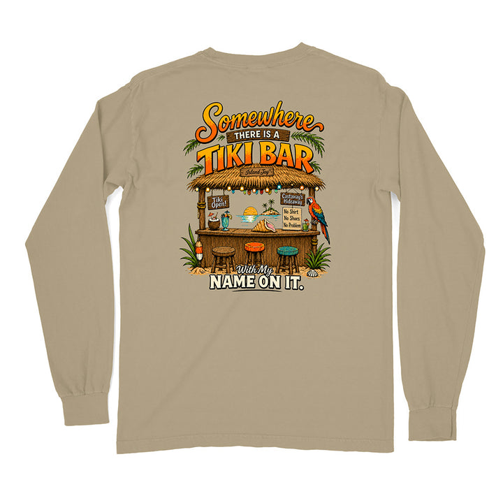 A beige long-sleeve t-shirt shown from the back, featuring a colorful graphic print of a tropical 'Tiki Bar' with the text 'Somewhere THERE IS A TIKI BAR' and 'With My NAME ON IT.'.