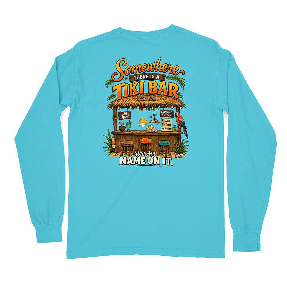 A light blue long-sleeve t-shirt shown from the back, featuring a colorful graphic of a tropical tiki bar with the text 'Somewhere THERE IS A TIKI BAR' and 'Add My NAME ON IT.'.