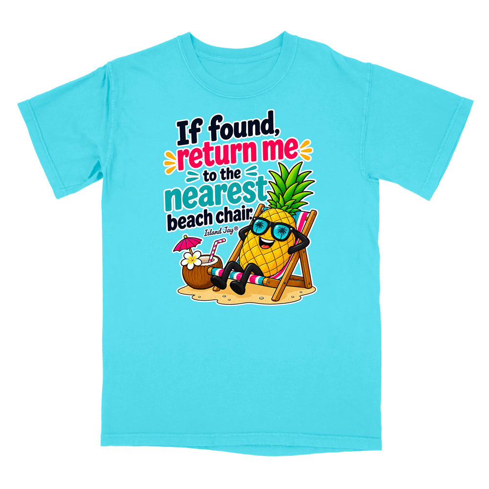 A light blue short-sleeve crewneck t-shirt featuring a colorful graphic of a pineapple wearing sunglasses and relaxing in a beach chair next to a coconut drink, with the text 'If found, return me to the nearest beach chair' and 'Shark Rayz' printed on the front.
