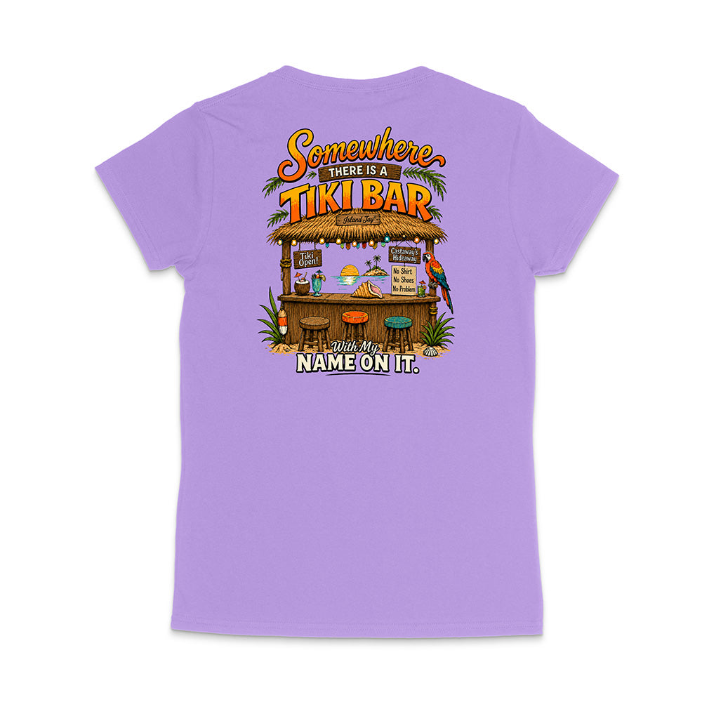A light purple short-sleeve t-shirt shown from the back, featuring a colorful graphic of a tropical 'Tiki Bar' with the text 'Somewhere there is a TIKI BAR' and 'With my NAME ON IT.'.
