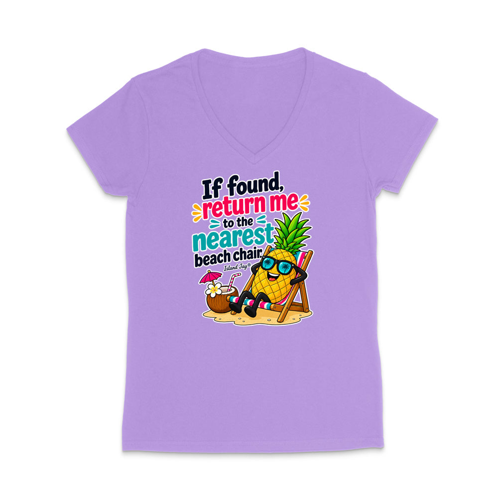 A light purple short-sleeve V-neck t-shirt with a colorful graphic on the front. The graphic features a cartoon pineapple wearing sunglasses and sitting in a beach chair next to a coconut drink, with the text 'If found, return me to the nearest beach chair.
