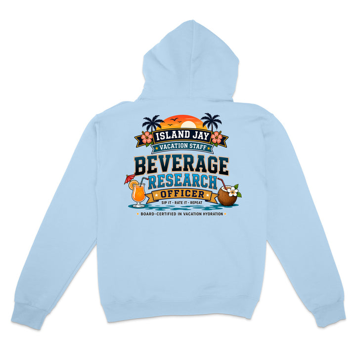 A light blue hooded sweatshirt shown from the back, featuring a colorful graphic print that reads 'ISLAND JAY BEVERAGE RESEARCH OFFICER' with tropical illustrations including palm trees, a sunset, a cocktail, and a coconut drink.