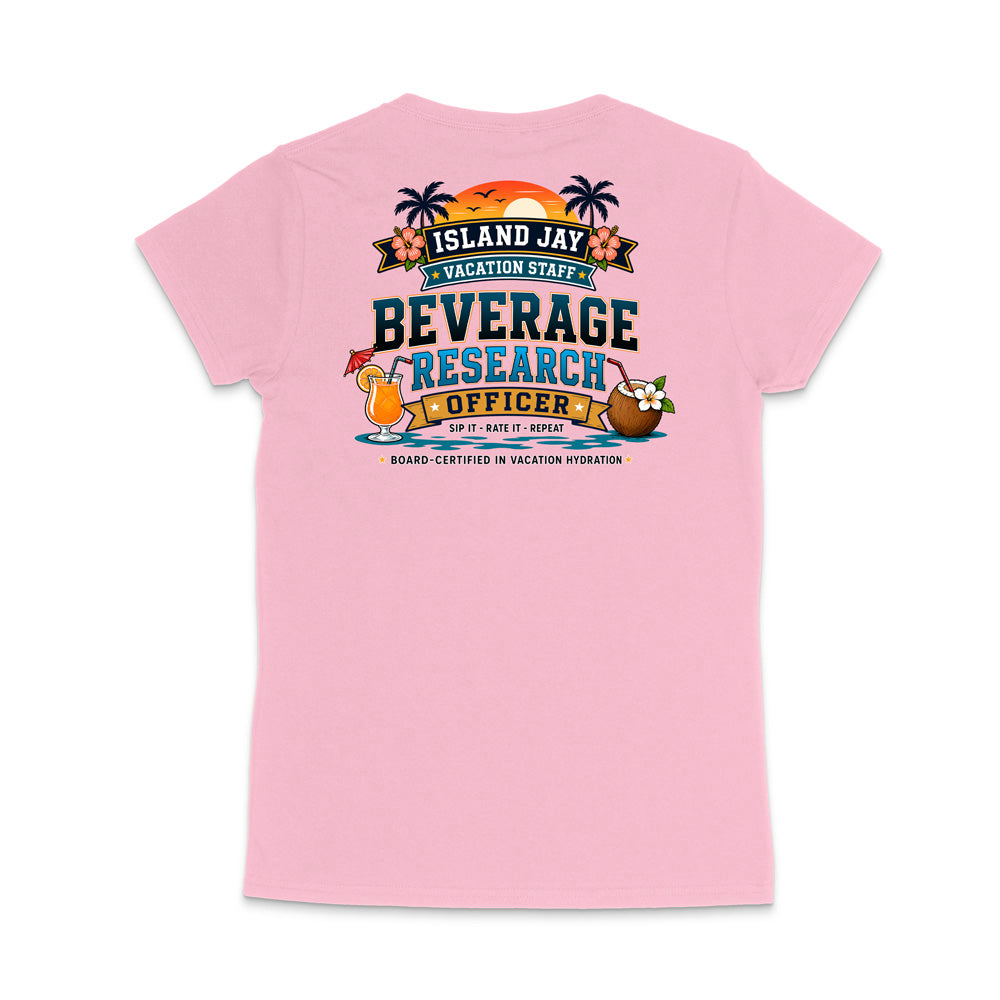 A light pink short-sleeve t-shirt shown from the back, featuring a colorful graphic print with tropical island-themed text reading 'ISLAND JAY VACATION STAFF BEVERAGE RESEARCH OFFICER' and cartoon cocktail and coconut illustrations.