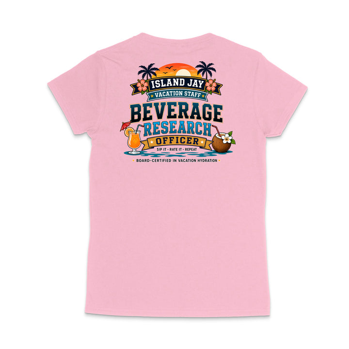 A light pink short-sleeve t-shirt shown from the back, featuring a colorful graphic print with tropical island-themed text reading 'ISLAND JAY VACATION STAFF BEVERAGE RESEARCH OFFICER' and cartoon cocktail and coconut illustrations.