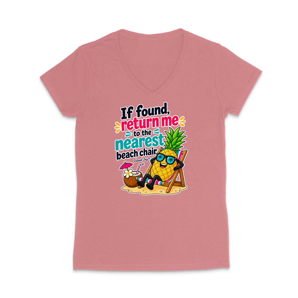 A dusty pink women's V-neck t-shirt with a colorful graphic of a pineapple character wearing sunglasses and reclining in a beach chair next to a coconut shell umbrella, with the text 'If found, return me to the nearest beach chair.'.