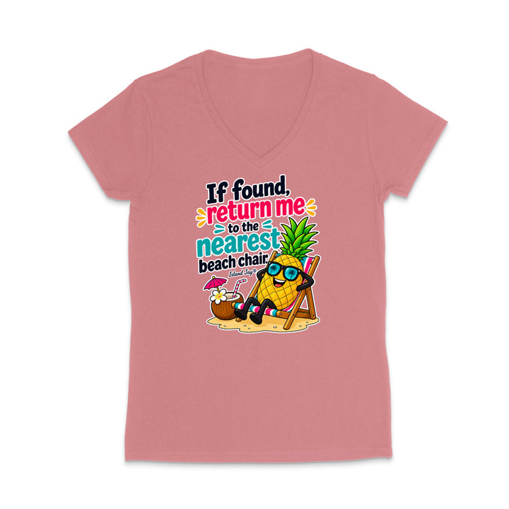 A dusty pink women's V-neck t-shirt with a colorful graphic of a pineapple character wearing sunglasses and reclining in a beach chair next to a coconut shell umbrella, with the text 'If found, return me to the nearest beach chair.'.