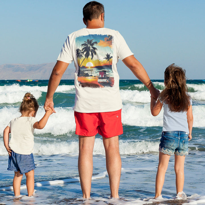 Moments of Tranquility in Paradise T-Shirt Worn by a man stepping into the ocean with his kids