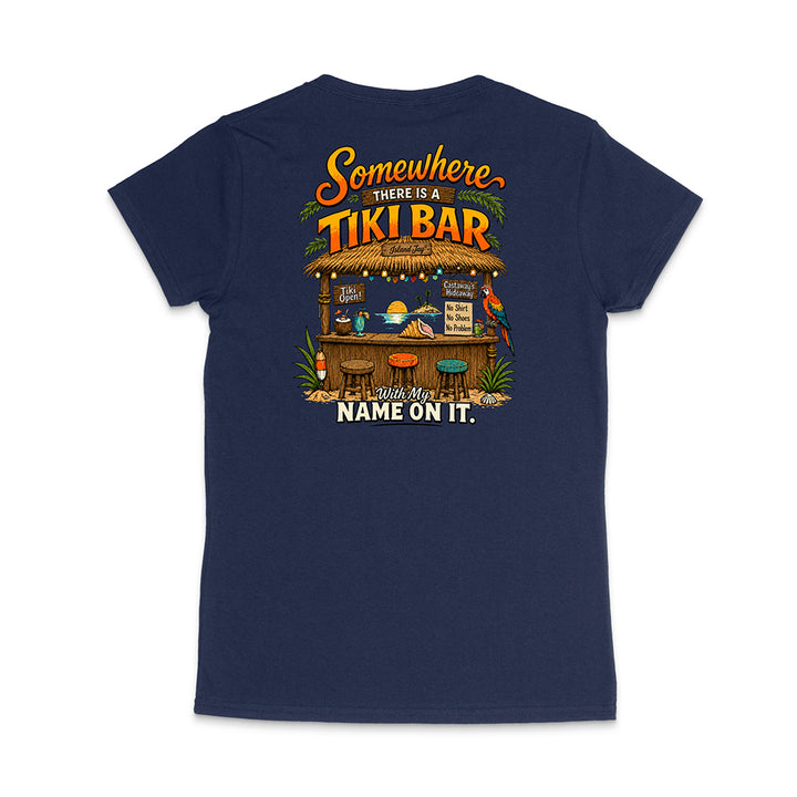A navy blue short-sleeve t-shirt shown from the back, featuring a colorful graphic print of a tropical 'Tiki Bar' with the text 'Somewhere there is a TIKI BAR' and 'Wish Your NAME ON IT.'.