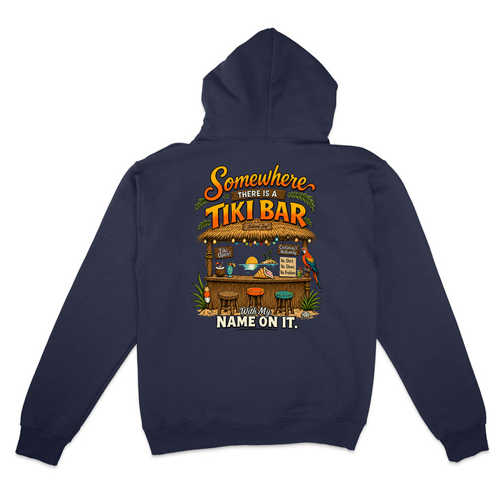 A navy blue hoodie shown from the back, featuring a colorful graphic print of a tiki bar with the text 'Somewhere THERE IS TIKI BAR' and 'NAME ON IT.'.