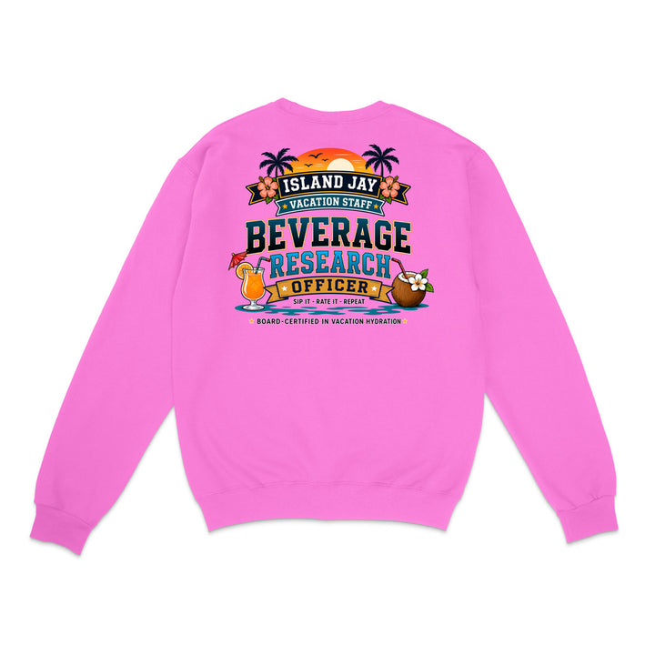 A bright pink crewneck sweatshirt shown from the back, featuring a colorful graphic print with tropical elements and the text 'ISLAND JAY BEVERAGE RESEARCH OFFICER'.