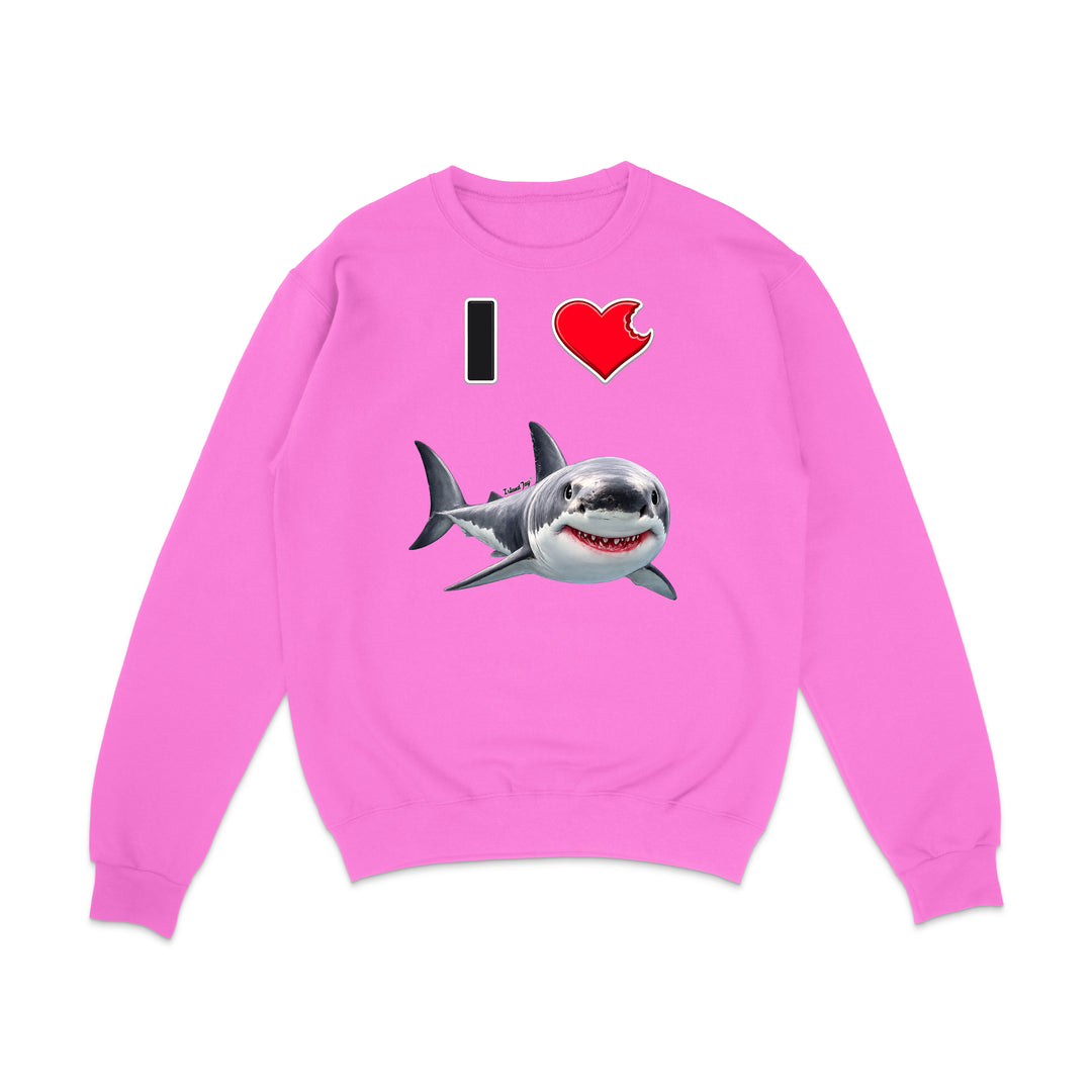 A bright pink crewneck sweatshirt featuring a graphic print of a great white shark and the text 'I' followed by a red heart, displayed on a clean white background.