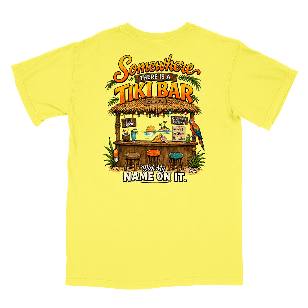 A bright yellow short-sleeve t-shirt shown flat against a white background, featuring a colorful graphic print on the back with a tiki bar illustration and the text 'Somewhere there is a TIKI BAR' and 'I'll have my NAME ON IT.'.