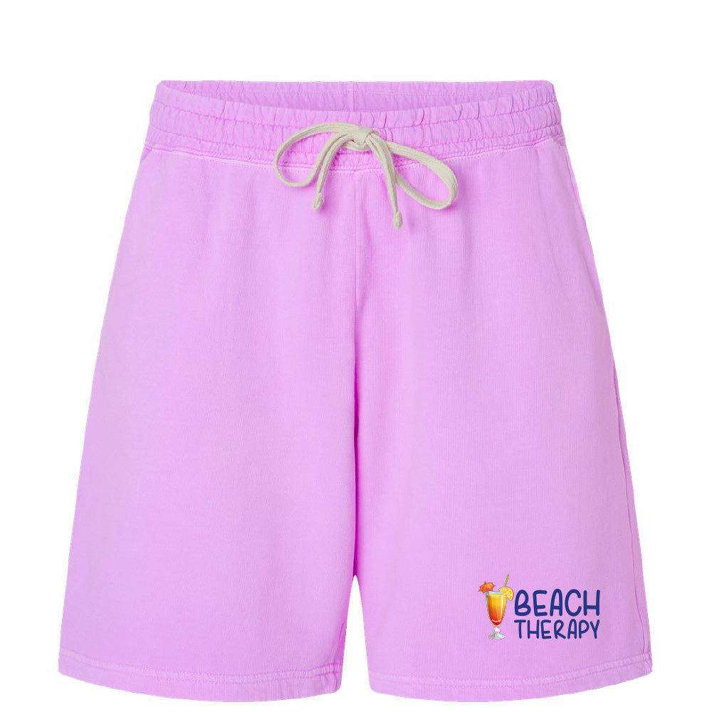 Purple shorts with 'Beach Therapy' text and logo on a white background