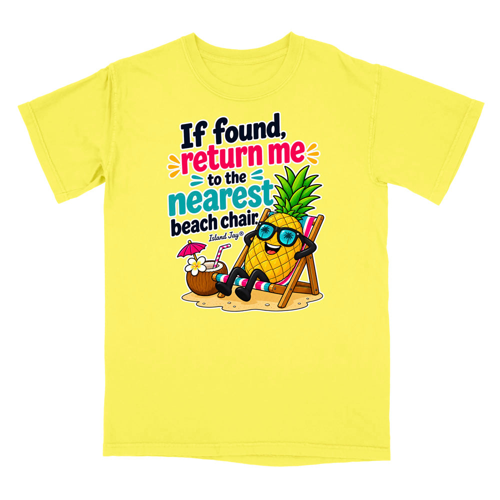 A bright yellow short-sleeve t-shirt with a colorful graphic print on the front. The graphic features a cartoon pineapple wearing sunglasses and reclining in a beach chair next to a coconut drink, with the text 'If found, return me to the nearest beach chair' and 'Island Style' printed below.
