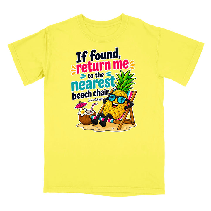 A bright yellow short-sleeve t-shirt with a colorful graphic print on the front. The graphic features a cartoon pineapple wearing sunglasses and reclining in a beach chair next to a coconut drink, with the text 'If found, return me to the nearest beach chair' and 'Island Style' printed below.
