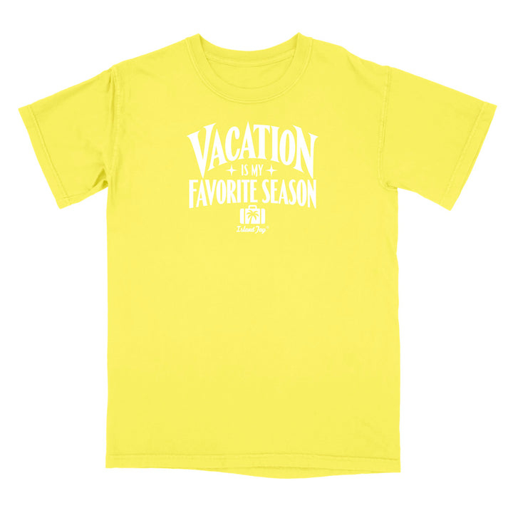 A bright yellow short-sleeve t-shirt with a white graphic print on the front that reads 'VACATION IS MY FAVORITE SEASON' with a small 'Travel Dog' logo underneath, displayed on a clean white background.