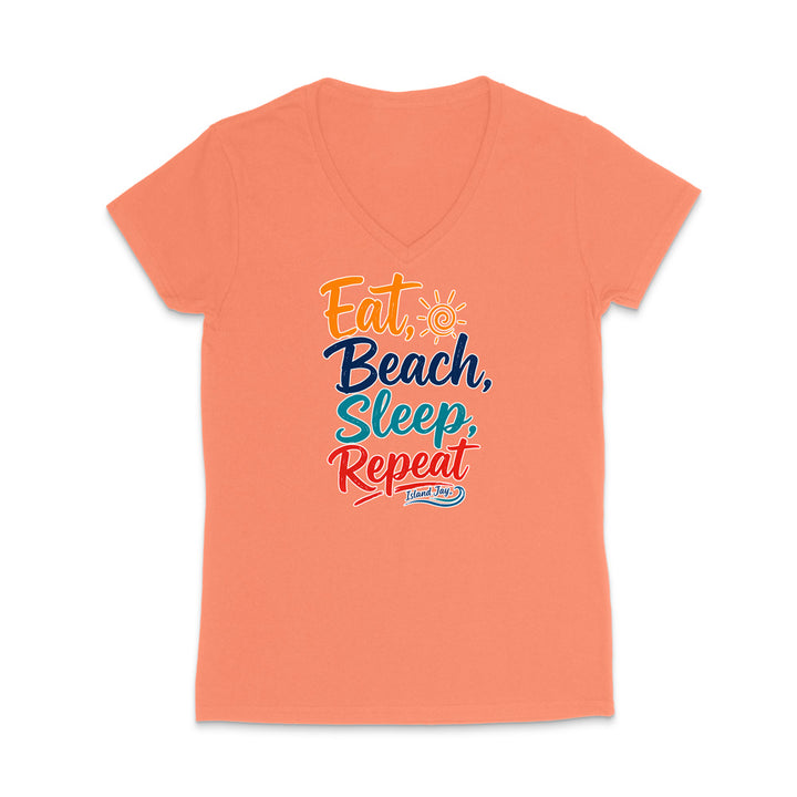 A coral pink V-neck t-shirt with a colorful graphic text design reading 'Eat, Beach, Sleep, Repeat' in orange, navy, and red lettering, displayed on a clean white background.