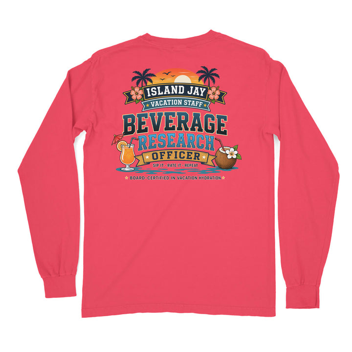 A pink long-sleeve t-shirt shown from the back, featuring a colorful graphic print with tropical island-themed text reading 'ISLAND JAY VACATION STAFF BEVERAGE RESEARCH OFFICER' and cartoon cocktail and coconut illustrations.