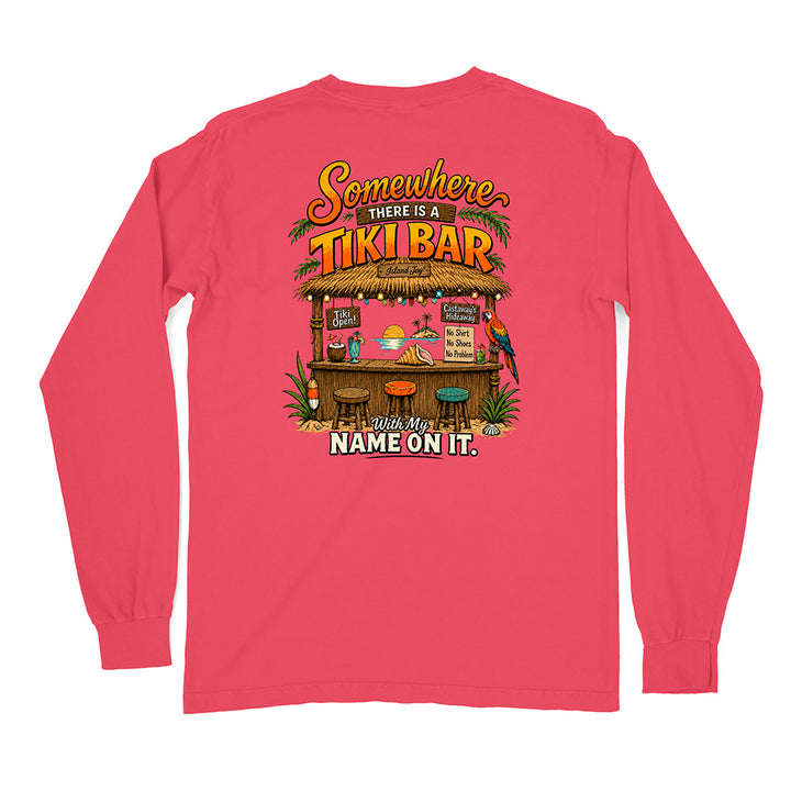 A bright pink long-sleeve t-shirt with a colorful graphic on the front. The graphic features a tropical beach bar scene with the text 'Somewhere THERE IS A TIKI BAR' and 'With My NAME ON IT.