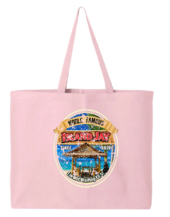 A light pink canvas tote bag featuring a circular graphic print on the front that reads 'World Famous Island Jay' with a beach scene and a thatched-roof structure.