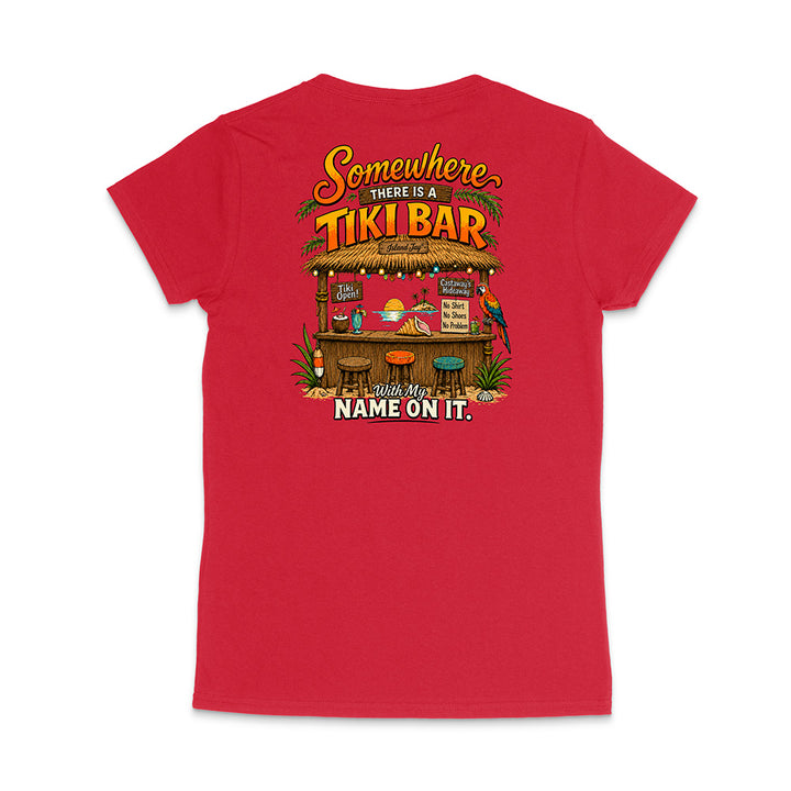 A red short-sleeve t-shirt shown from the back, featuring a colorful graphic print of a tropical Tiki Bar with the text 'Somewhere THERE IS A TIKI BAR' and 'With My NAME ON IT.'.