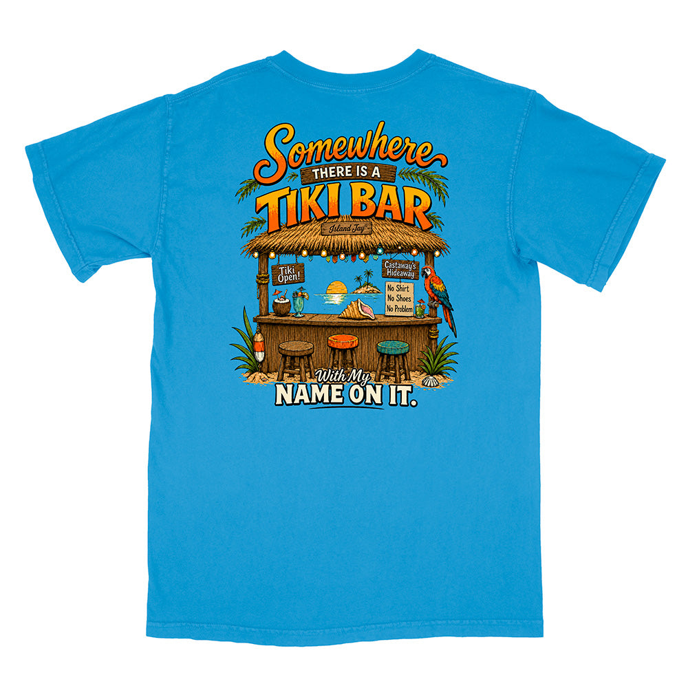 A bright blue short-sleeve t-shirt with a large, colorful graphic on the back. The graphic features a tropical tiki bar scene with a parrot, drinks, and the text 'Somewhere THERE IS A TIKI BAR With My NAME ON IT.