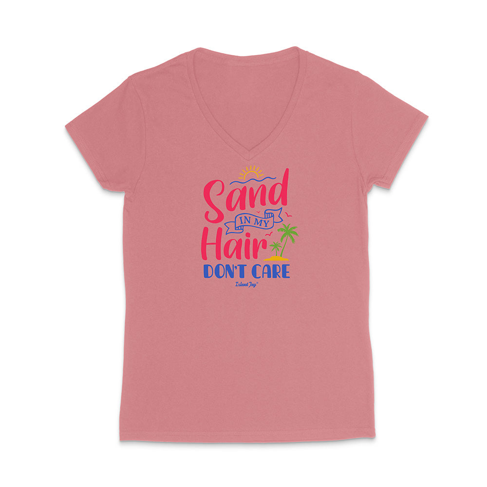 Pink t-shirt with colorful text reading "Sand In My Hair Don't Care" on a white background