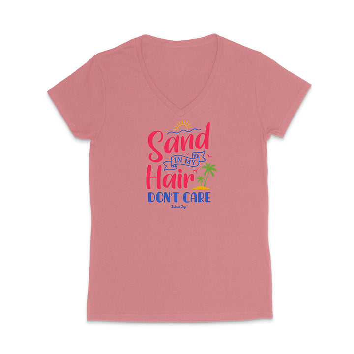 Pink t-shirt with colorful text reading "Sand In My Hair Don't Care" on a white background