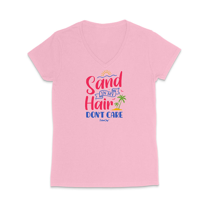 Pink t-shirt with colorful text reading "Sand In My Hair Don't Care" on a white background