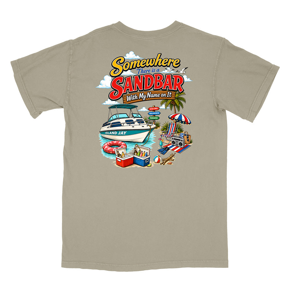 A light tan crewneck t-shirt with a colorful graphic print on the front. The graphic features a white speedboat with 'SANDBAR' in red letters, beach umbrellas, a cooler, and the text 'Somewhere There Is SANDBAR With My Name on It'.