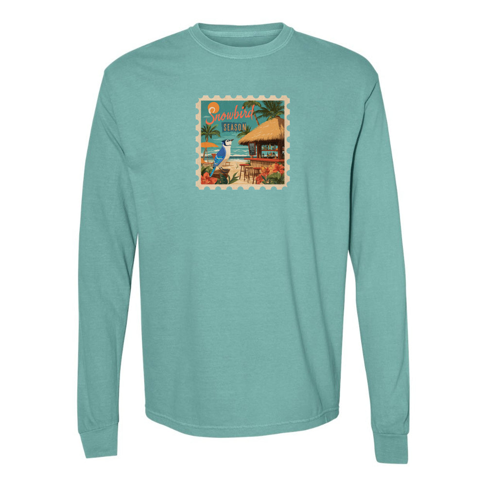 Teal long-sleeve shirt with a tropical design on a white background