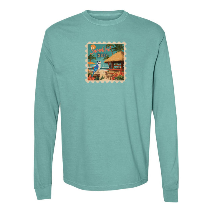 Teal long-sleeve shirt with a tropical design on a white background