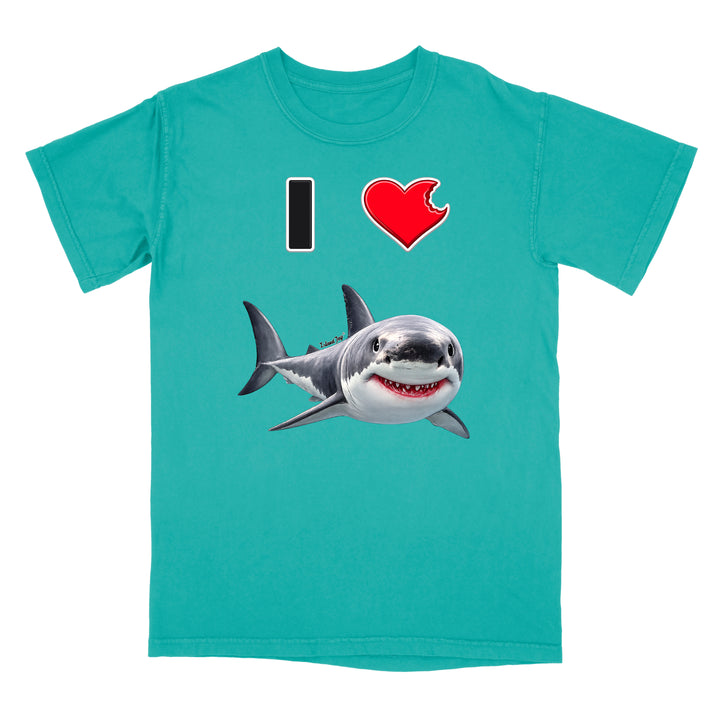 A turquoise short-sleeve crewneck t-shirt featuring a graphic print of a great white shark and the text 'I' followed by a red heart with a bite taken out of it, on a solid white background.