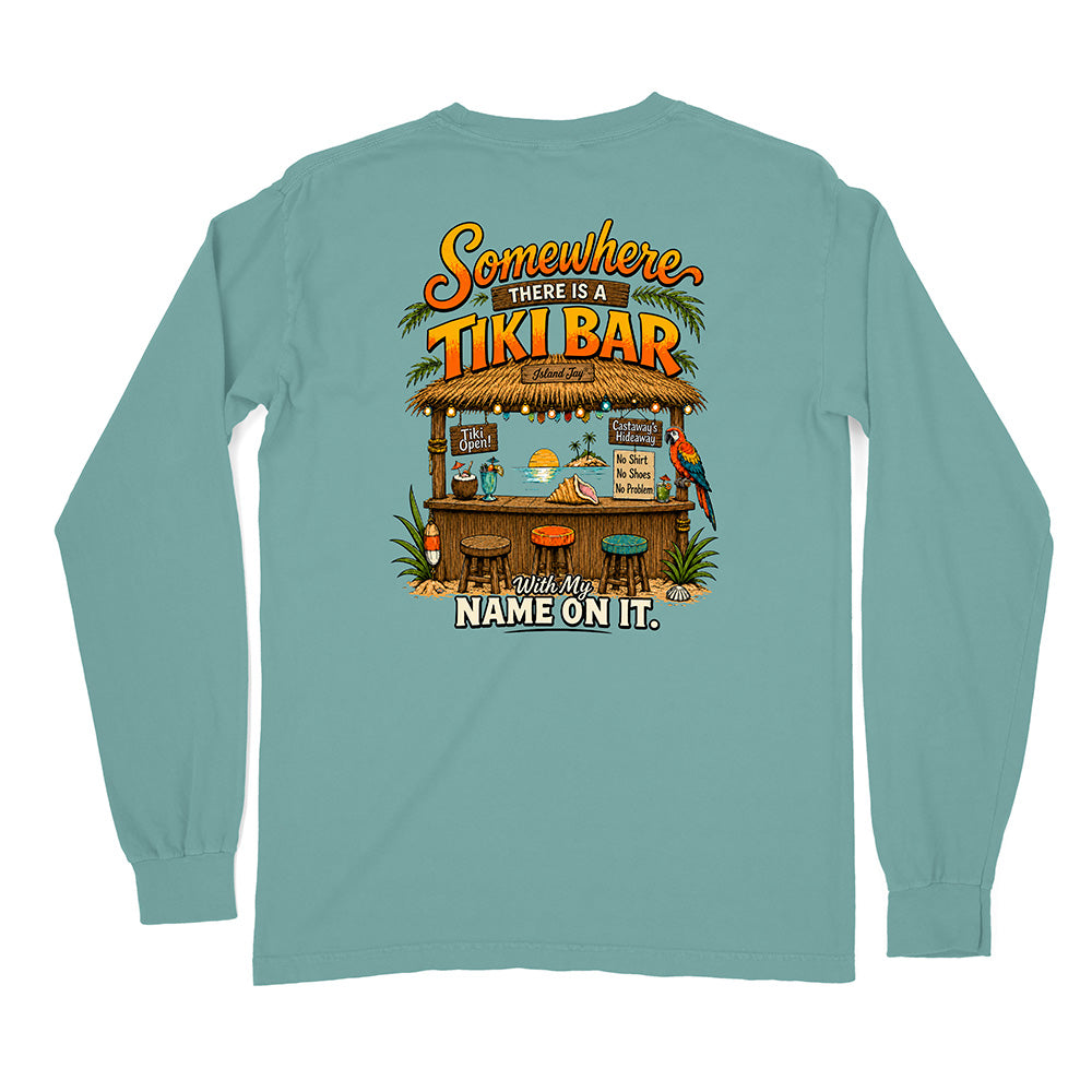 A long-sleeve t-shirt in a muted teal color, shown from the back. The back features a large, colorful graphic of a tropical beach bar with the text 'Somewhere THERE IS A TIKI BAR' and 'With My NAME ON IT.