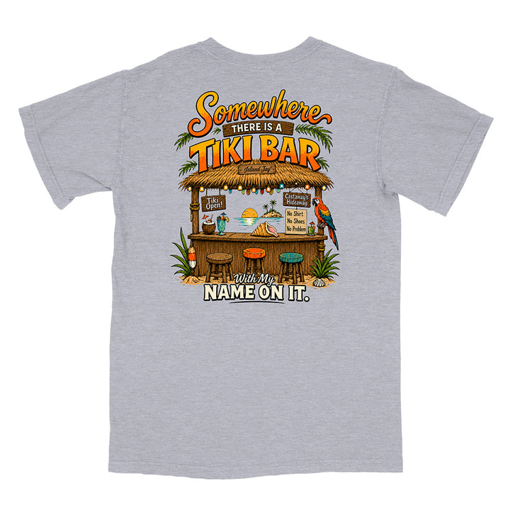 A heather gray short-sleeve t-shirt shown from the back, featuring a large, colorful graphic print of a tropical tiki bar with the text 'Somewhere THERE IS A TIKI BAR' and 'With My NAME ON IT.'.