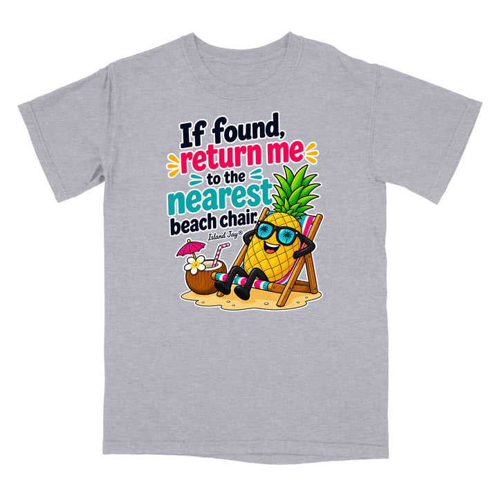 A heather gray short-sleeve t-shirt with a colorful graphic on the front. The graphic features a cartoon pineapple wearing blue sunglasses and sitting in a beach chair next to a coconut drink, with the text 'If found, return me to the nearest beach chair' and 'Island Style'.