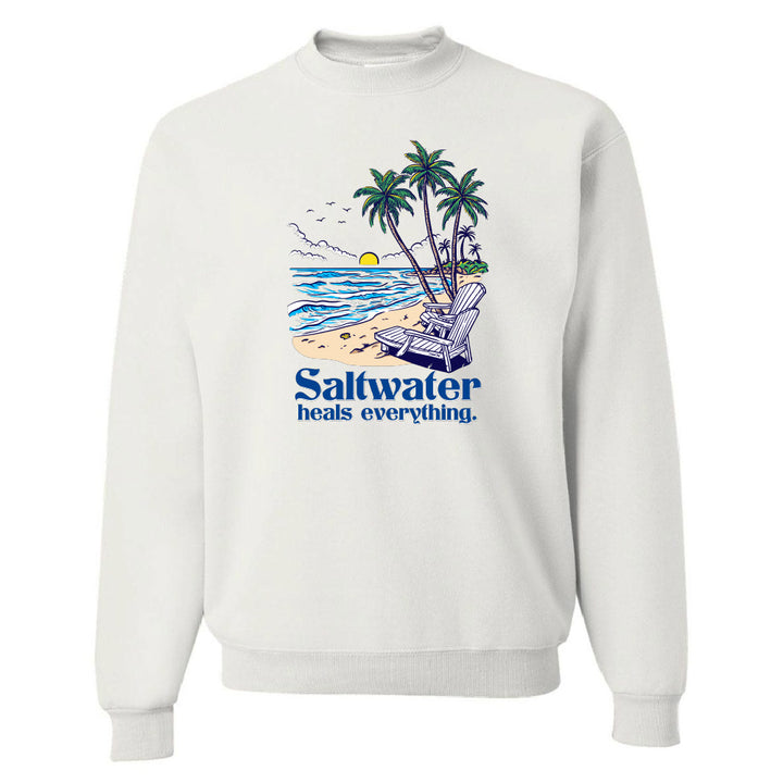 White sweatshirt with a beach graphic and 'Saltwater heals everything' text on a white background