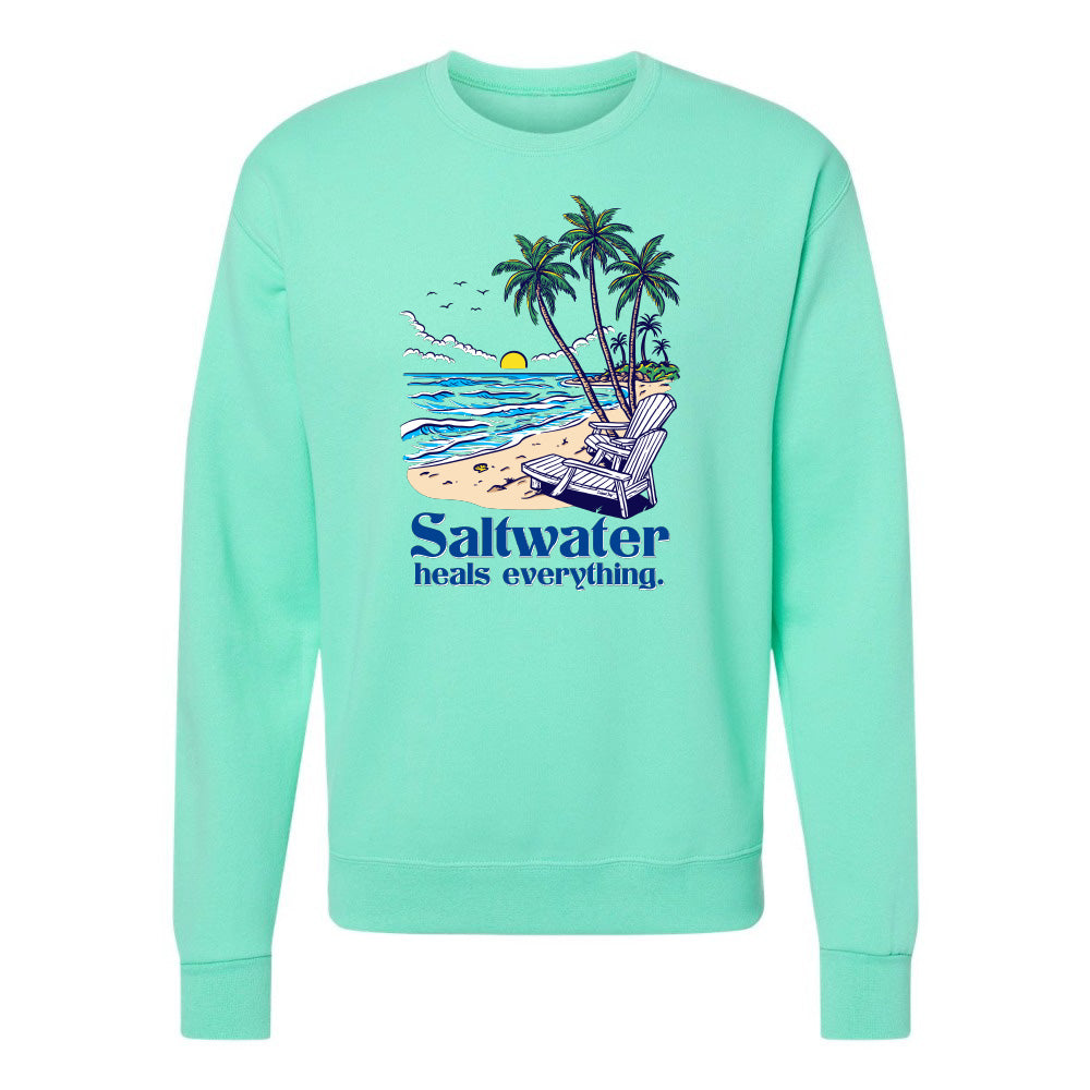 Mint green sweatshirt with beach graphic and 'Saltwater heals everything' text on a white background