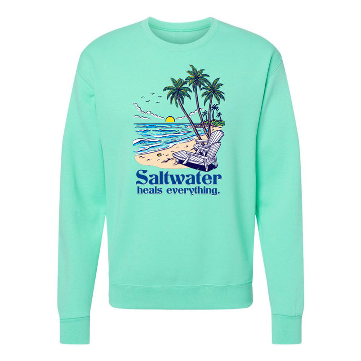 Mint green sweatshirt with beach graphic and 'Saltwater heals everything' text on a white background