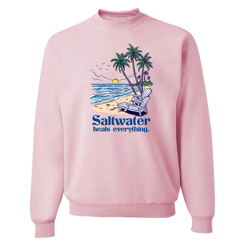 Pink sweatshirt with a beach graphic and 'Saltwater heals everything' text on a white background