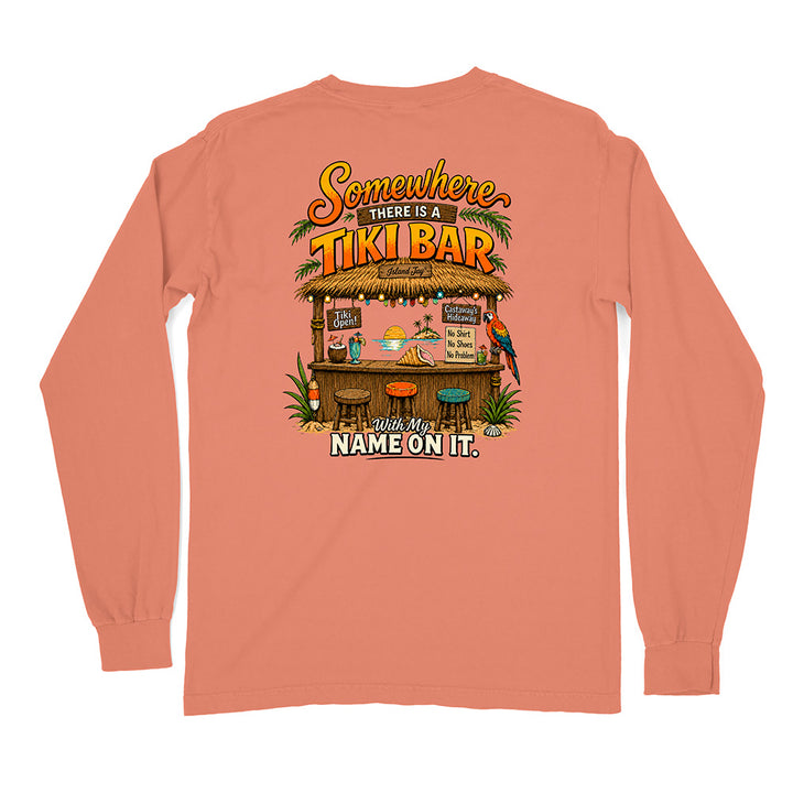 A coral pink long-sleeve t-shirt shown from the back, featuring a colorful graphic of a tropical Tiki bar with the text 'Somewhere THERE IS A TIKI BAR' and 'With My NAME ON IT.'.