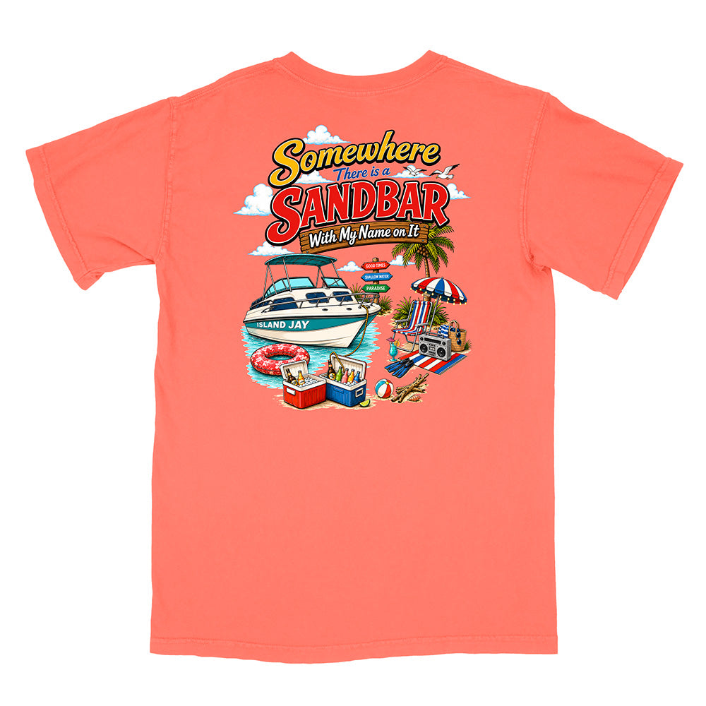 A coral pink short-sleeve t-shirt with a colorful graphic print on the front. The graphic features a white speedboat on blue water with the text 'SANDBAR' in large red letters, under the phrase 'Somewhere There is a SANDBAR With My Name on It' in yellow script.
