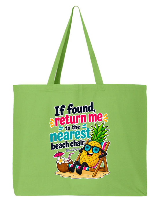 A light green canvas tote bag with long handles, featuring a colorful graphic print of a pineapple character relaxing in a beach chair with the text 'If found, return me to the nearest beach chair.'.
