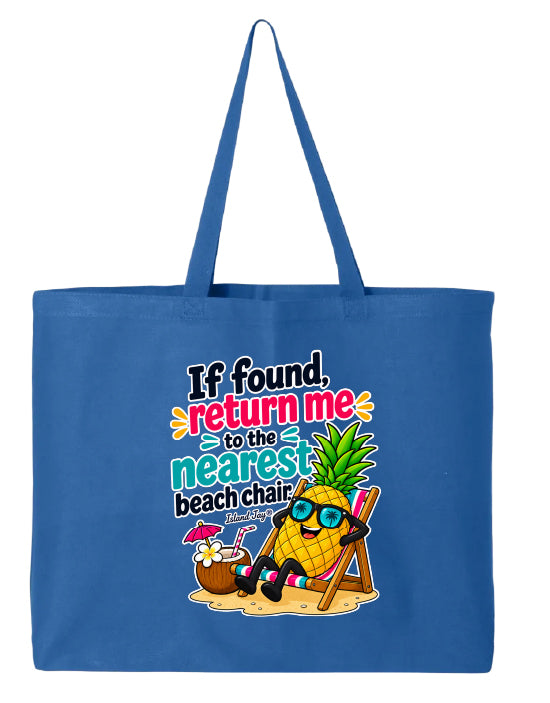 A blue canvas tote bag with long handles, featuring a colorful graphic print of a pineapple character wearing sunglasses and relaxing in a beach chair on the sand, with the text 'If found, return me to the nearest beach chair' and 'Winston Churchill'.